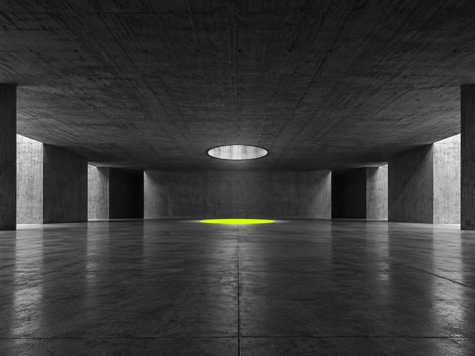 A round opening in a dark concrete ceiling, casting a pool of fluoro-yellow light on the floor.